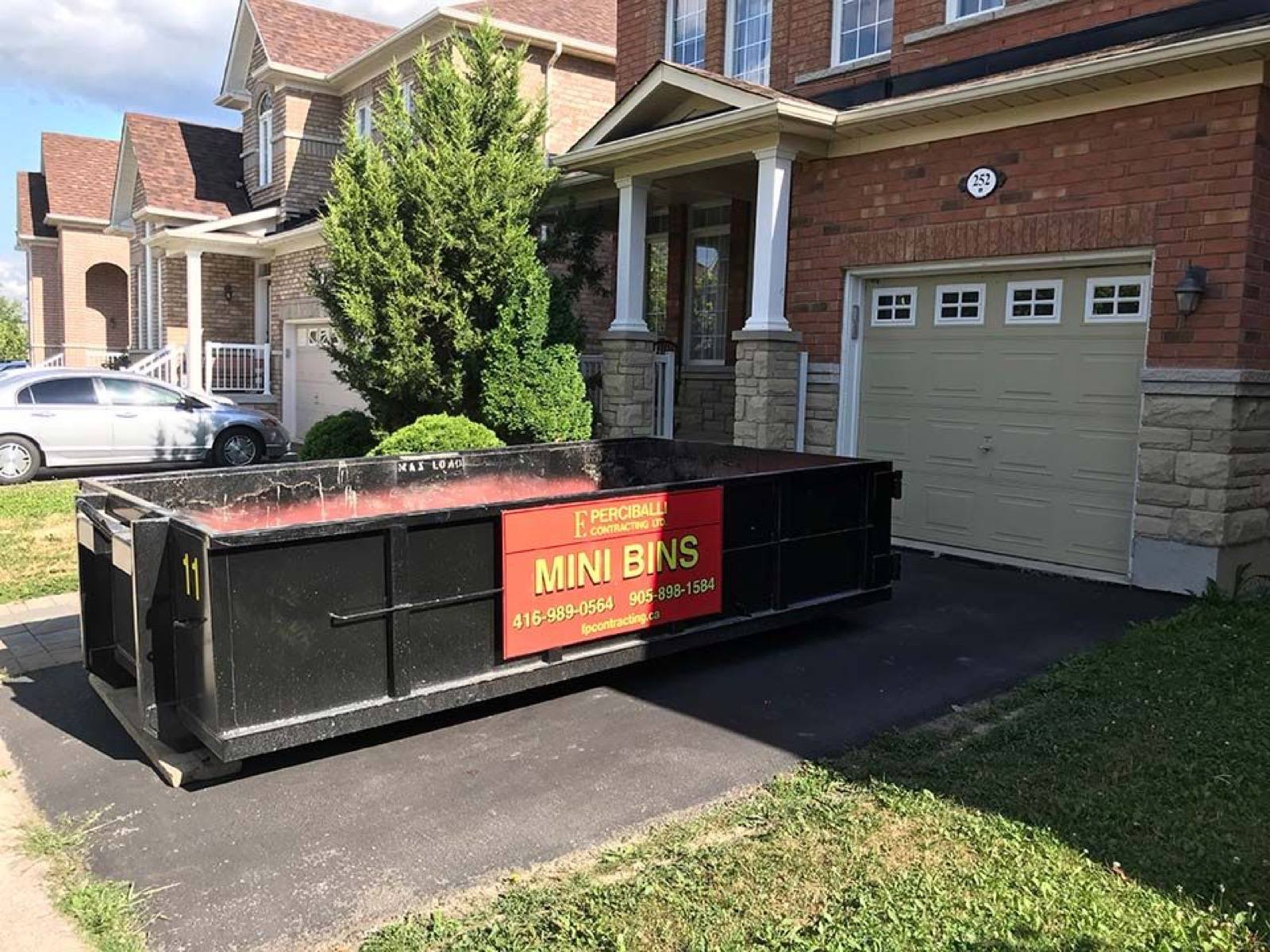 dust bin placed in front of a garage door 